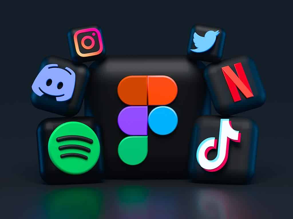 3d render of six floating cubes, each featuring a different popular social media logo: instagram, twitter, discord, figma, spotify, and tiktok, against a dark background.