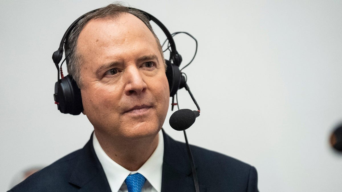A middle-aged man wearing a suit and a headset with a microphone, looking attentively to the side. He appears to be engaged in listening or communication about proposed laws in a professional setting.