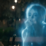 A translucent, ghostly figure of a young woman appears in a nighttime park setting, illuminated by soft, glowing star lights in the background that create a mystical atmosphere.