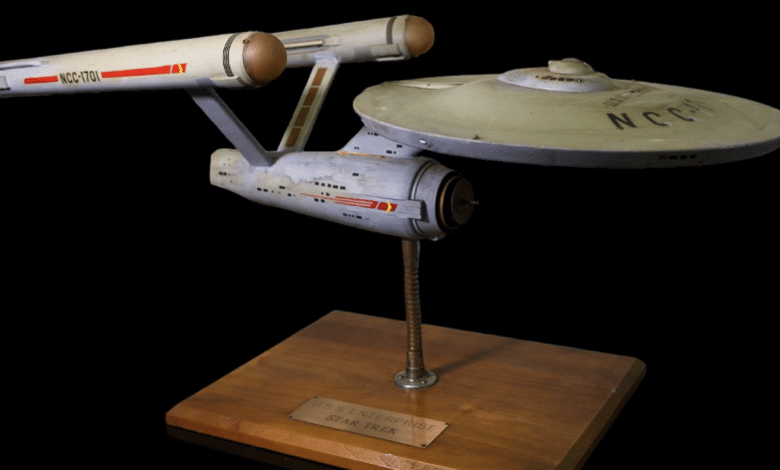 A model of the starship Enterprise from Star Trek, with "NCC-1701" on the hull, mounted on a stand with a plaque reading "U.S.S. Enterprise Star Trek T