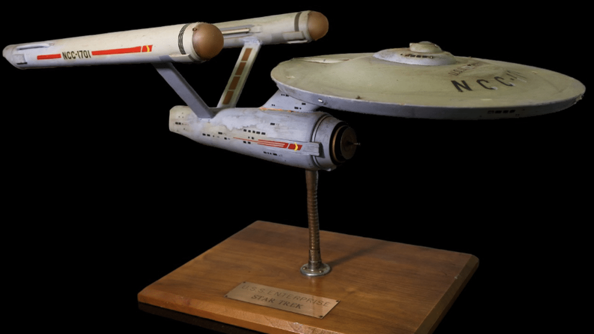 A model of the starship Enterprise from Star Trek, with "NCC-1701" on the hull, mounted on a stand with a plaque reading "U.S.S. Enterprise Star Trek T