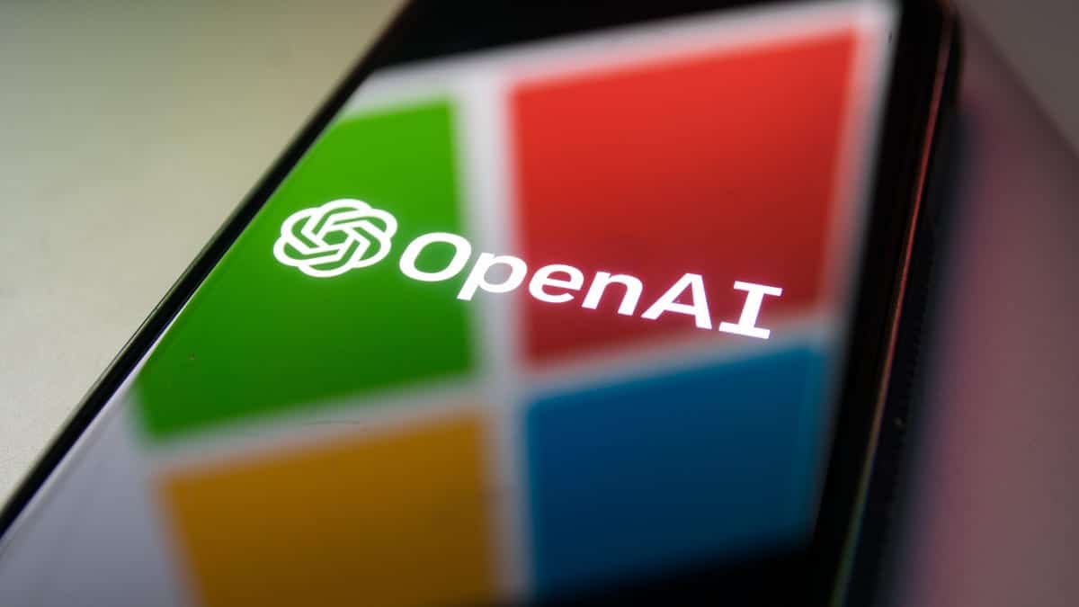 A smartphone screen displaying the OpenAI logo, which features a stylized white 's' in a Microsoft green circular outline, set against a colorful square background split into red, green, blue