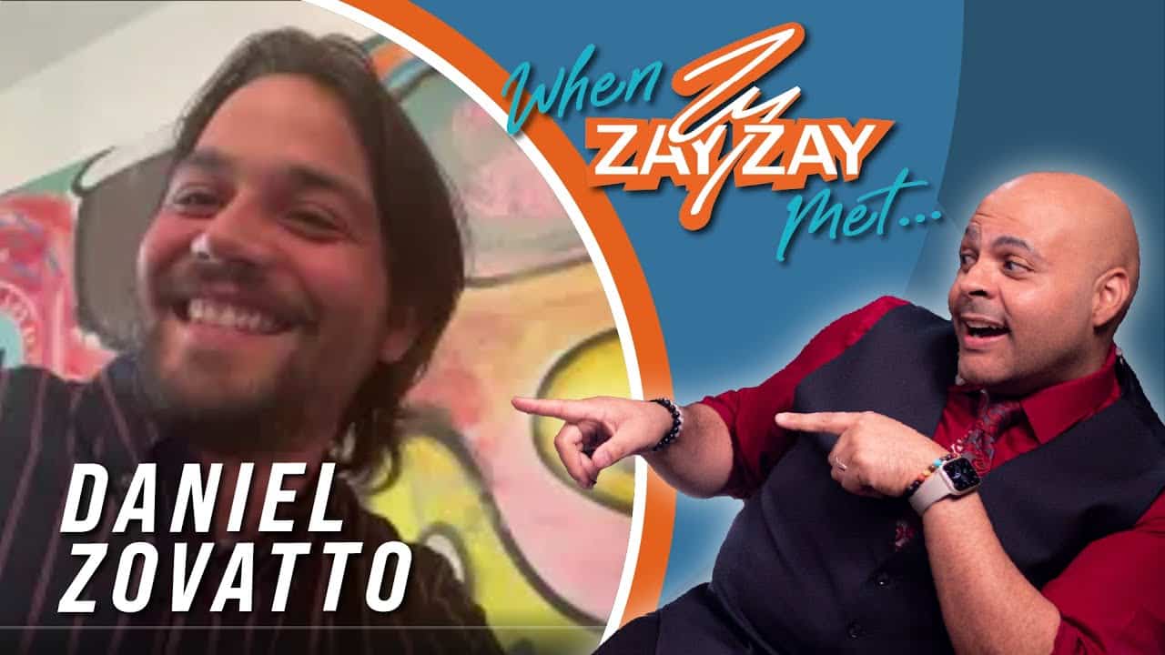 Split-screen image with Daniel Zovatto smiling on the left, and a man on the right pointing at the text "Exclusive Interview with Daniel Zovatto" above his own image. Both are in