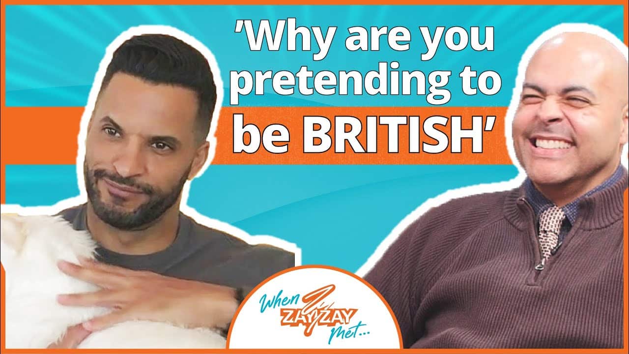 Two men in a video thumbnail; the left man with a beard holds a white dog and looks amused, while the right bald man laughs. The text reads "Hilarious Conversation with British Action Star