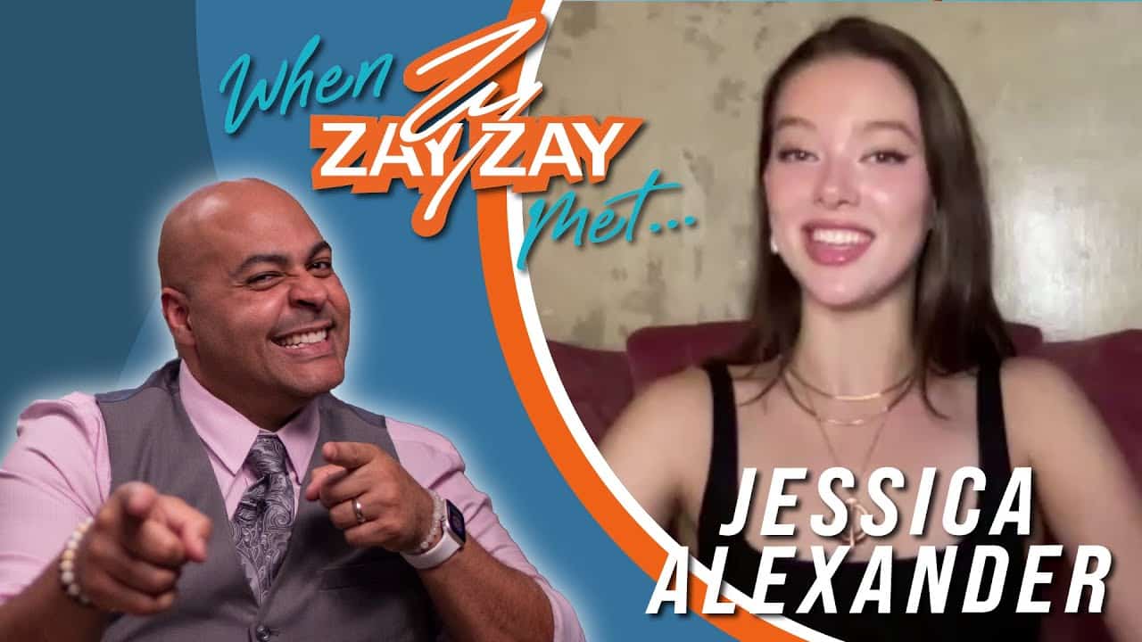 Promotional image for a video interview featuring a smiling bald man in a purple shirt pointing enthusiastically at the camera, and a cheerful young woman in a black top on a video call screen, with text