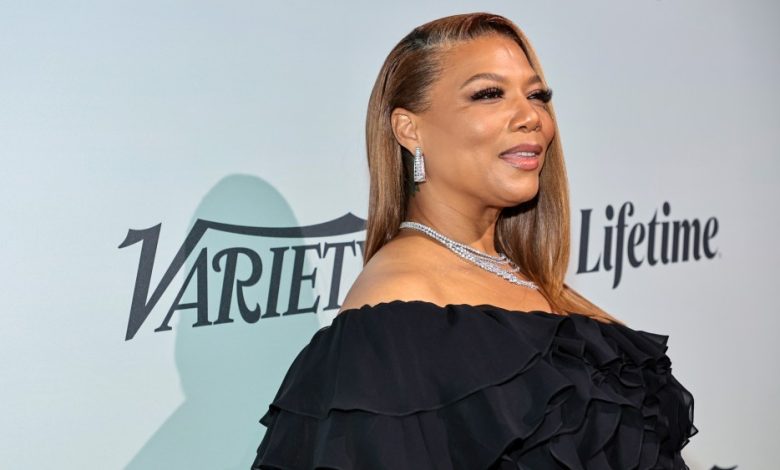 Queen Latifah attends an event, wearing a black ruffled outfit and sparkling diamond jewelry. The background features the 'Variety' logo and a light tone. She smiles subtly at the camera as