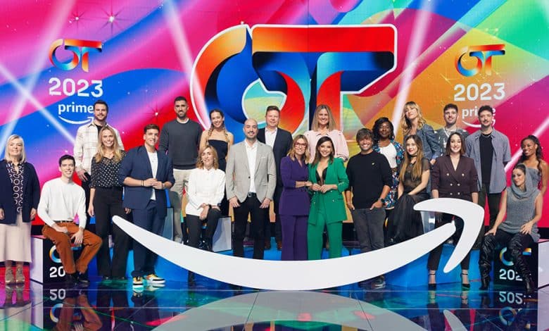 Group of people posing on a colorful stage with "2023" and various logos, including a stylized "gt" and "Prime," indicating a television or event setting led by 'Operación Tri