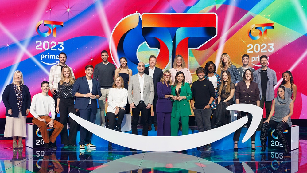 Group of people posing on a colorful stage with "2023" and various logos, including a stylized "gt" and "Prime," indicating a television or event setting led by 'Operación Tri