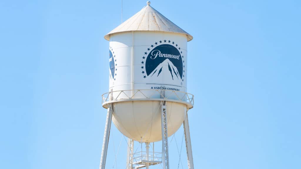 A white water tower with the paramount pictures logo and the words "paramount," "a viacom company" under a clear blue sky during the streaming wars.