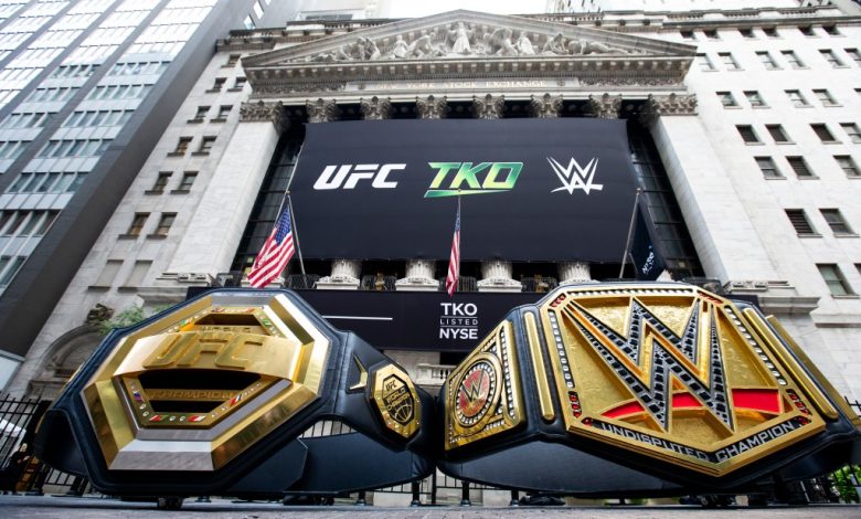 Two championship belts, one labeled "ufc" and the other "wwe," are displayed in front of a large screen showing ufc tko and wwe logos, with the New York Stock