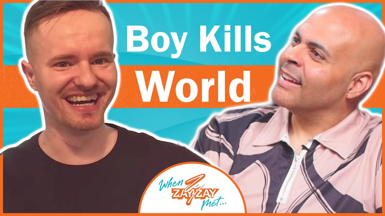 Two men smiling during an interview, one with a short beard and the other bald, framed by a vibrant orange and blue background with the text "boy kills world" and "when zayzay met..." visible.