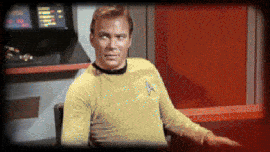 An animated gif from "Star Trek" showing Captain Kirk in a yellow uniform, seated on the bridge, making expressive gestures while speaking, with colorful control panels in the background.