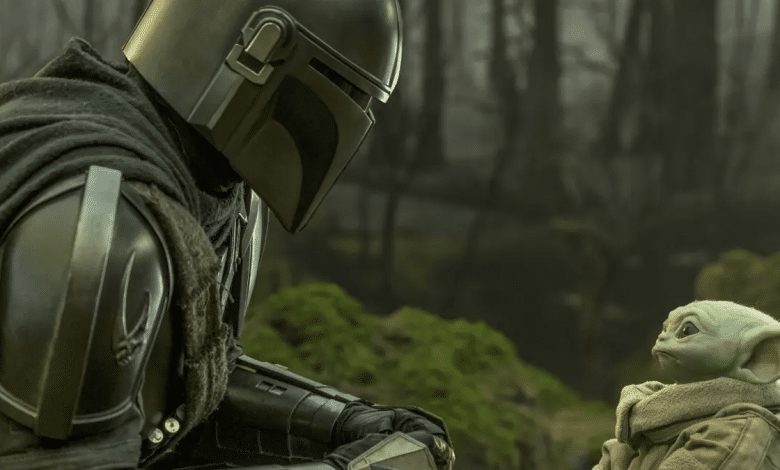 The Mandalorian in armor gazes at Grogu, who looks back with curiosity, in a misty forest environment. The focus is on their interaction, highlighting the contrast between the Mandalorian's metallic