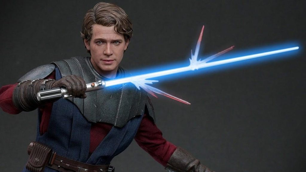 A realistic figurine of a young man with wavy hair, wielding a light saber with blue beams emitting from both ends. He wears a rugged outfit with a grey vest and brown belt, poised for