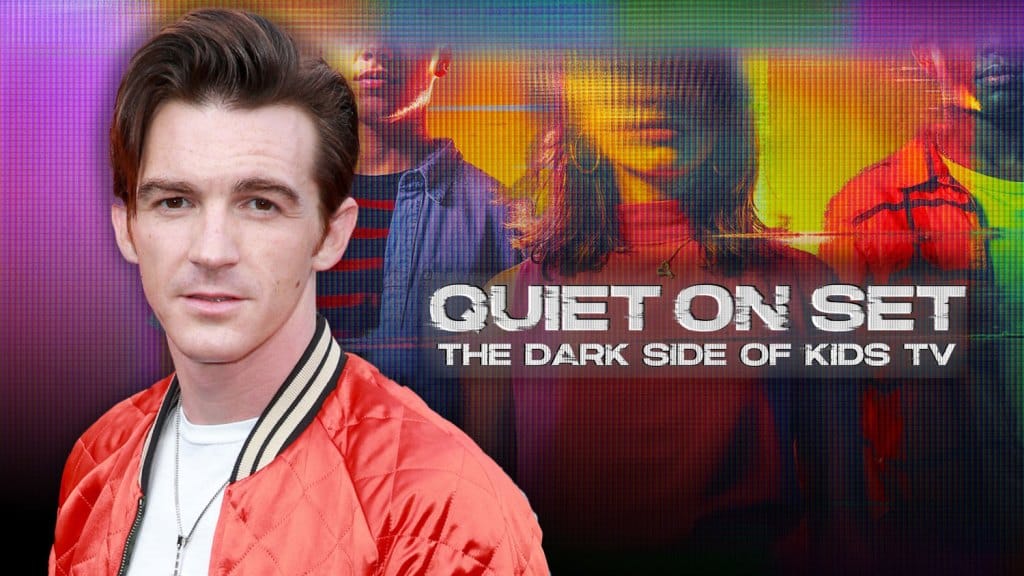 A man with dark hair styled in a quiff, wearing a red satin jacket, is superimposed over a colorful graphic background featuring blurred images of young actors and the phrase "Quiet On Set