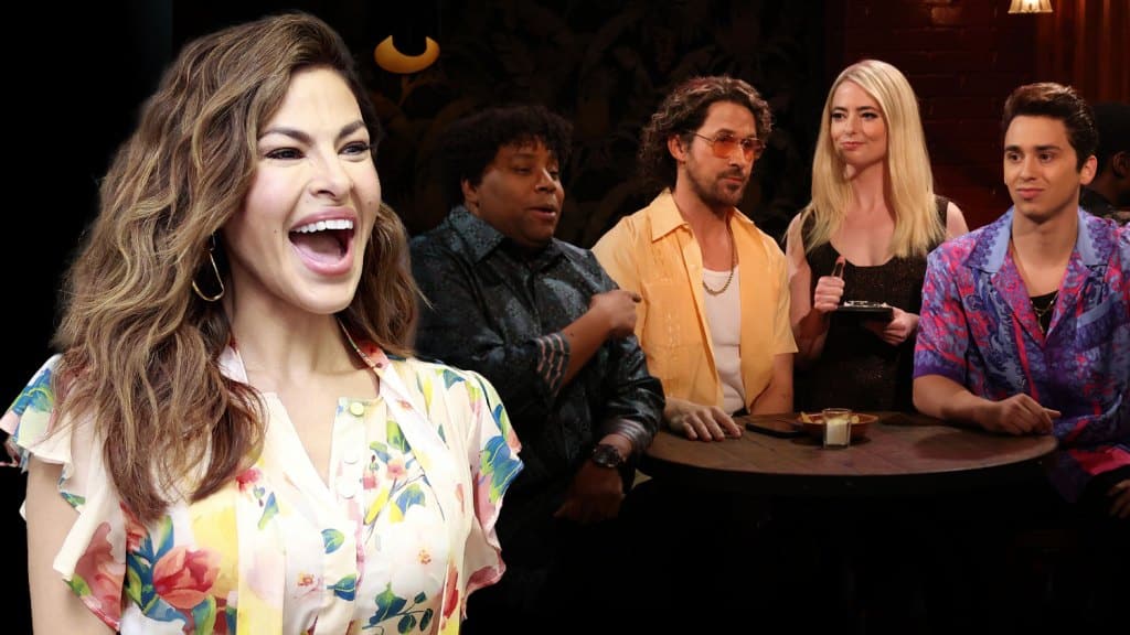 A woman with brown hair, resembling Eva Mendes, wearing a floral blouse, laughing joyfully. Behind her, five people sit at a bar, engaged in a discussion. The scene is warmly lit
