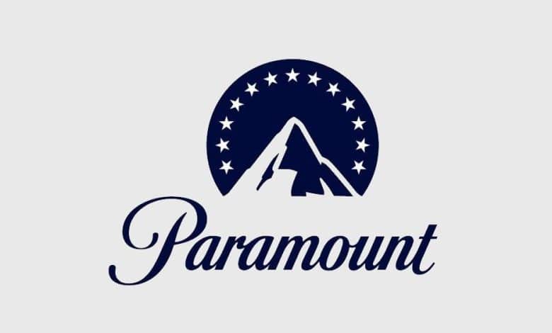 Logo of paramount featuring a stylized mountain peak inside a circle adorned with stars, in dark blue on a light gray background, with the word "paramount" in a curved, elegant script below.