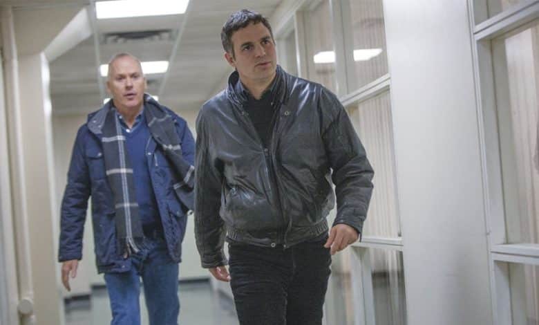 Two men walk through an office corridor with wood-paneled walls. The man in the foreground, featured in a black jacket and maintaining a serious expression, is depicted with diverse storytelling elements, while the man