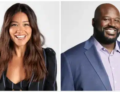 Gina Rodriguez & Shaquille O’Neal, two smiling individuals—a woman with long brown hair wearing a black blouse and a man with a bald head wearing a blue blazer and purple shirt—posed against a white background.