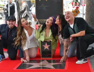 Jenni Rivera''s adult children,, A group of five people pose around a newly unveiled star on the Hollywood Walk of Fame. They are kneeling on a red carpet and looking up excitedly. The star is held by one woman in a bright green suit. Four other people, two in white outfits, one in gray, and one in black, smile and point.