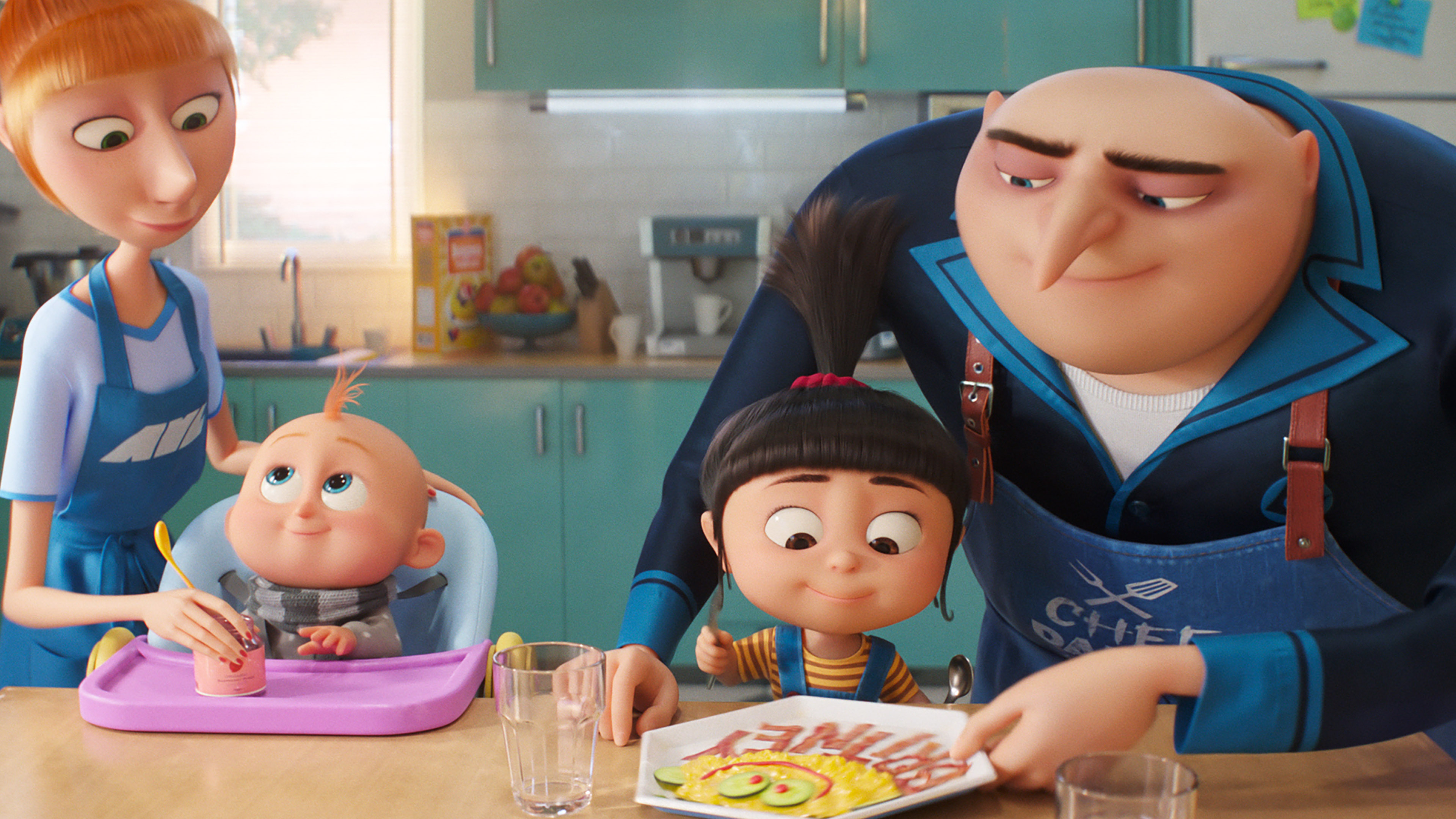 A family scene from an animated film shows a mother feeding a baby in a high chair, a young girl excitedly looking at a colorful pancake, and a man with a prominent nose smiling at the girl. The setting is a bright kitchen with light blue cabinets and various kitchen items, reminiscent of Universal Pictures' charming style.