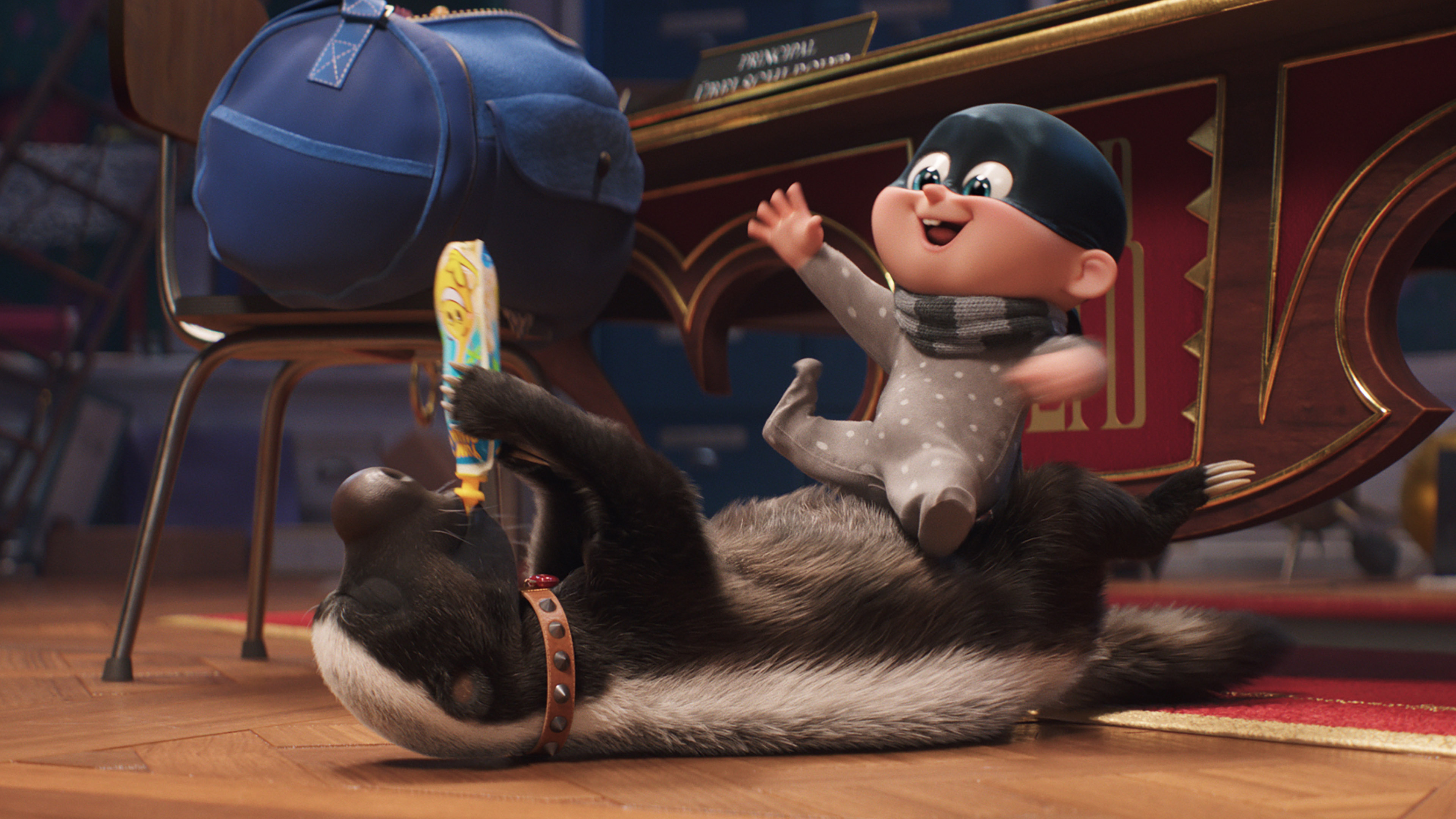 A delighted baby wearing a gray onesie and a black mask joyfully rides on the back of a lounging skunk inside a cozy room. The skunk, reminiscent of characters from *Despicable Me 4*, wears a brown collar and lies belly-up, holding a children's book. A blue backpack rests on a nearby chair and an ornate wooden desk is partially visible.