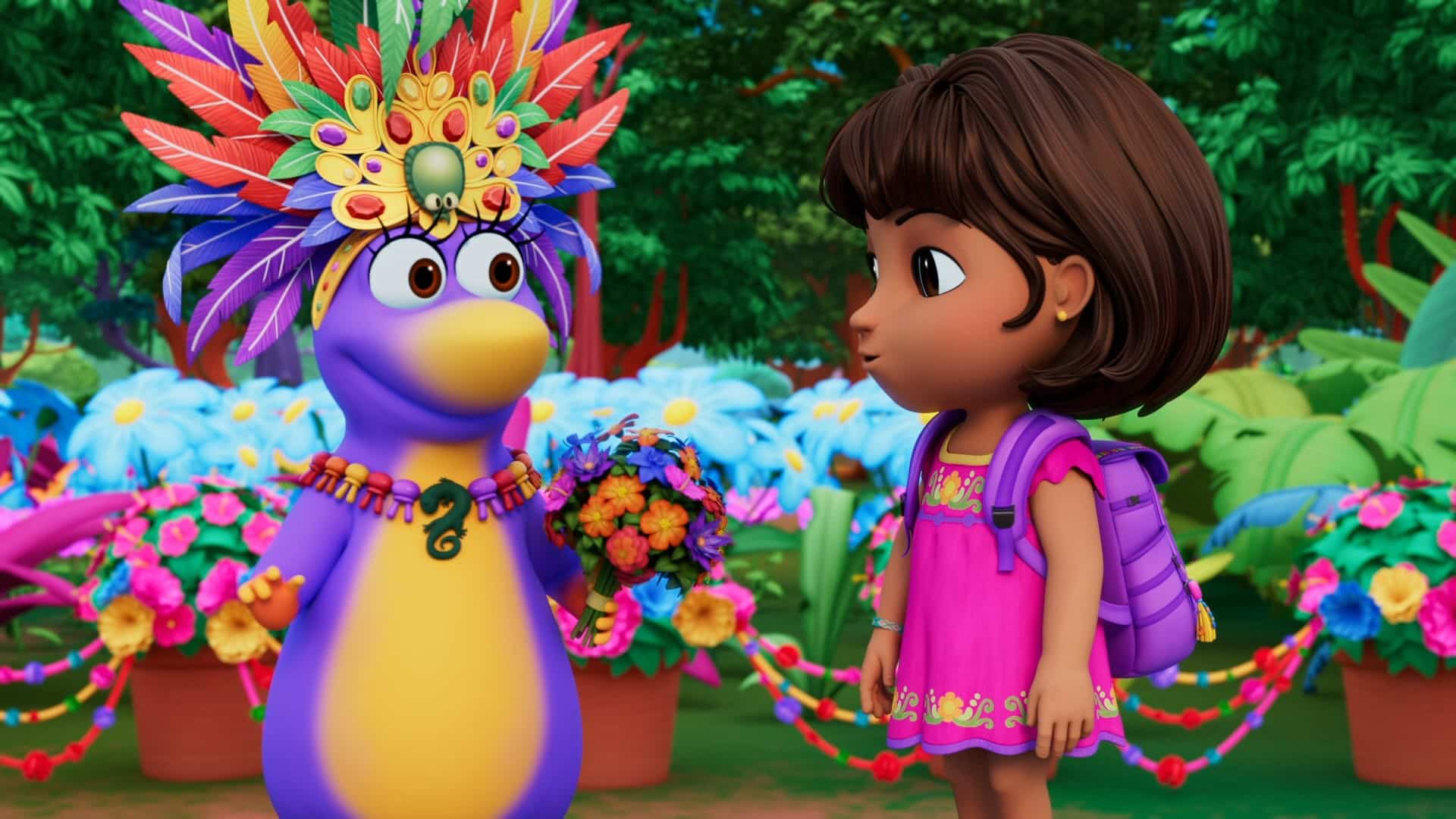 A colorful animated scene showing a young girl with brown hair and a pink dress standing next to a penguin wearing a vibrant feathered headdress and necklace. They are surrounded by large, brightly colored flowers and greenery, with the penguin holding a bouquet of flowers.