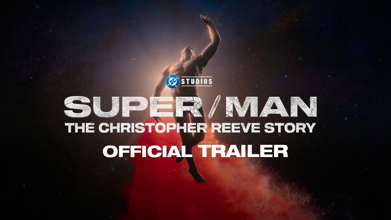 A muscular figure reaches upward, surrounded by a red cloud and starlit sky backdrop. Prominent text reads "SUPER / MAN" above "THE CHRISTOPHER REEVE STORY" in bold, white letters. Smaller, centered text beneath says "OFFICIAL TRAILER". The DC Studios logo is visible at the top.