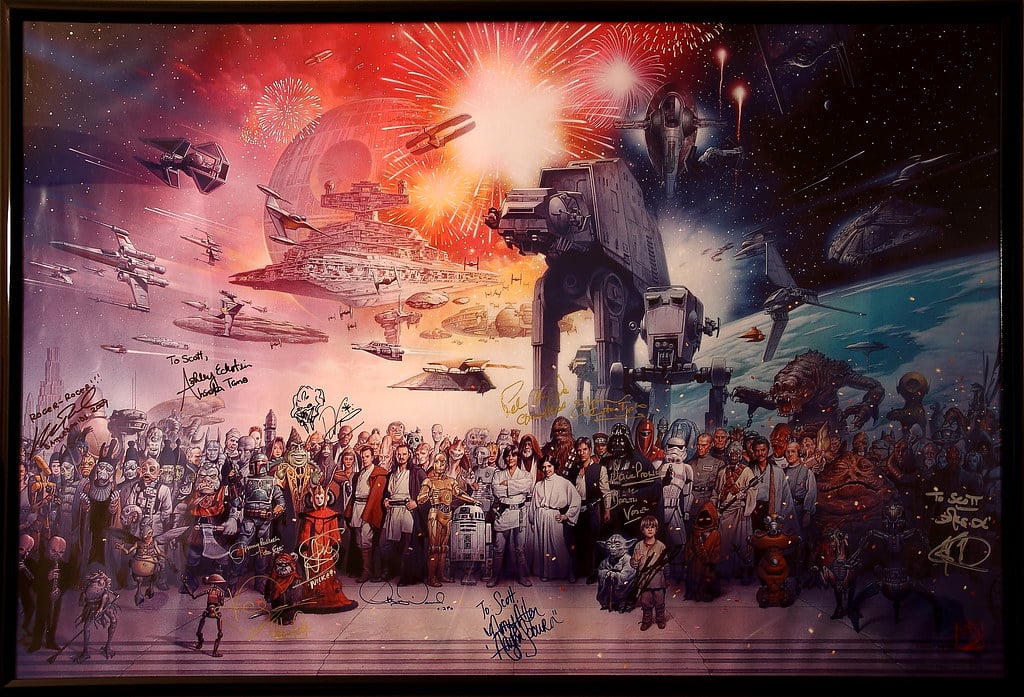 A vibrant Star Wars montage with characters from various episodes, including Jedi, droids, starships, and scenes of galactic battles. The background features an explosion with starships, and many characters are autographed in silver and gold ink spread throughout the image.