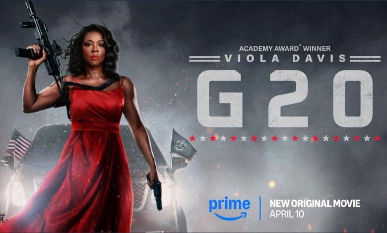 A woman in a red dress holds a rifle and a gun, standing confidently. She is in front of a smokey background with flags. Text reads "Academy Award Winner Viola Davis G20." Prime logo and release date, April 10, are at the bottom. The image conveys intensity and action.