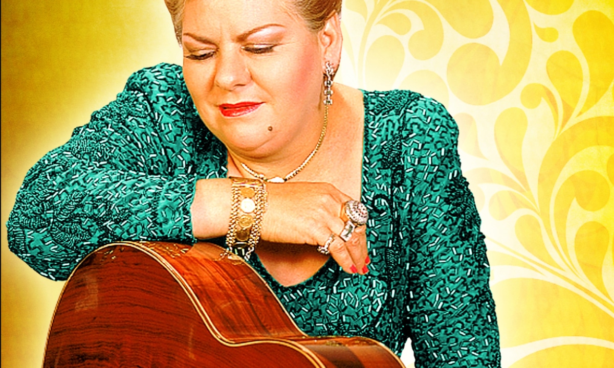 Paquita la del Barrio, a woman with her hand on a guitar